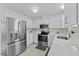 Modern kitchen features stainless steel appliances, white cabinets, and stylish backsplash at 215 Bradbury Ave, Oak Hill, FL 32759