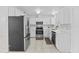 Bright kitchen featuring stainless steel appliances, white cabinets, and tile flooring at 215 Bradbury Ave, Oak Hill, FL 32759