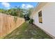 Long side yard view shows house siding, fence, and landscaping at 215 Bradbury Ave, Oak Hill, FL 32759