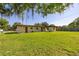 Expansive backyard with lush green grass, shaded by mature trees, offers ample outdoor space at 2222 Catherine St, Kissimmee, FL 34741