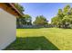 Large backyard featuring a grassy lawn, fenced perimeter, and mature trees, ideal for outdoor activities at 2222 Catherine St, Kissimmee, FL 34741