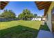 Grassy backyard with a wooden perimeter fence and lush trees, providing ample space at 2222 Catherine St, Kissimmee, FL 34741