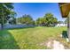 Wide-open backyard with a full lawn, bordered by a wooden fence and greenery, offering serene outdoor space at 2222 Catherine St, Kissimmee, FL 34741