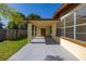 Side exterior featuring a covered porch with painted support columns and adjacent multi-paned windows at 2222 Catherine St, Kissimmee, FL 34741