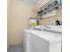 Functional laundry room with washer, dryer, water heater, shelving and overhead storage at 2222 Catherine St, Kissimmee, FL 34741