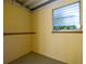 Shed interior featuring painted yellow walls, concrete flooring, and a small jalousie window at 2222 Catherine St, Kissimmee, FL 34741