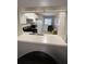 A kitchen with white cabinets and a breakfast bar with a view into laundry room at 2236 Stonington Ave # 2236, Orlando, FL 32817