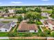 Aerial view of a house and neighborhood surrounded by mature trees, landscaping, a fence, and a nearby lake at 2344 Whispering Maple Dr., Orlando, FL 32837