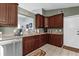 Functional kitchen featuring granite counters, wood cabinets, modern appliances, and a breakfast bar overlooking living area at 2344 Whispering Maple Dr., Orlando, FL 32837