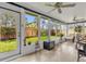Bright sunroom with tile floor, ceiling fans, and multiple windows offering a view of the fenced backyard at 2344 Whispering Maple Dr., Orlando, FL 32837