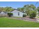 Exterior view of the home featuring a well-maintained yard and ample parking space on brick paved driveway at 2401 Mayer St, Orlando, FL 32806