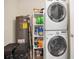 Functional laundry area with a stacked washer and dryer, storage shelves, and utility sink at 2401 Mayer St, Orlando, FL 32806