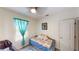 Cozy bedroom with daybed, bright turquoise curtains, and decorative artwork on the walls at 3044 Camino Real S Dr, Kissimmee, FL 34744