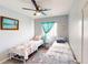 Bright bedroom with twin beds, a ceiling fan, and comfortable decor, creating a welcoming and relaxing atmosphere at 3044 Camino Real S Dr, Kissimmee, FL 34744