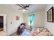 Cozy bedroom with daybed, massage chair, bright turquoise curtains, and decorative artwork on the walls at 3044 Camino Real S Dr, Kissimmee, FL 34744