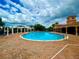 Resort-style community pool surrounded by a brick patio and comfortable lounge chairs at 3044 Camino Real S Dr, Kissimmee, FL 34744