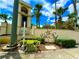 The Villa Sol community sign featuring lush tropical landscaping under a blue sky with fluffy clouds at 3044 Camino Real S Dr, Kissimmee, FL 34744