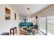 Bright dining area with glass table opens to living room with blue sofa and sliding glass doors to the patio at 3044 Camino Real S Dr, Kissimmee, FL 34744