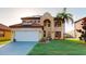 Inviting two-story home with a tile roof, lush lawn, and well-manicured landscaping at 3044 Camino Real S Dr, Kissimmee, FL 34744