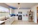 Modern kitchen featuring stainless steel appliances, white cabinets, and a large window, creating a bright and inviting space for cooking at 3044 Camino Real S Dr, Kissimmee, FL 34744