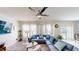 Cozy living room with large blue sectional sofa, ceiling fan, and plenty of natural light, perfect for relaxation and entertainment at 3044 Camino Real S Dr, Kissimmee, FL 34744