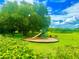 Community playground with a slide and swings, set amidst a lush green lawn and shady trees at 3044 Camino Real S Dr, Kissimmee, FL 34744