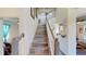 Bright staircase featuring wood stairs, white railings, and artwork at 3044 Camino Real S Dr, Kissimmee, FL 34744