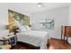 Bedroom with wood flooring, cozy bedding, and a serene, natural-themed mural at 3331 Windsor Lake Cir, Sanford, FL 32773
