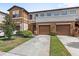 Inviting townhome with a well-manicured lawn, attached two-car garage, and neutral-tone exterior at 3331 Windsor Lake Cir, Sanford, FL 32773
