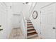 Bright foyer showcasing wood stairs, white doors, neutral tile floors, and modern decor at 3331 Windsor Lake Cir, Sanford, FL 32773