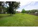 Spacious backyard with lush green grass, mature trees, and a fenced perimeter at 3443 Wild Myrtle Ct, Windermere, FL 34786