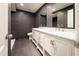 Bathroom featuring a double sink with marble countertops, grey tile and a separate toilet area at 3443 Wild Myrtle Ct, Windermere, FL 34786