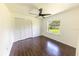 Bedroom with closet, fan, window with wooded view, and beautiful dark wood-look tile floors at 3443 Wild Myrtle Ct, Windermere, FL 34786