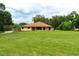 Exterior view of home on a sprawling green lawn with mature trees and blue skies at 3443 Wild Myrtle Ct, Windermere, FL 34786
