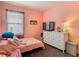 Comfortable pink bedroom with large window, dresser and TV at 348 Sigmund Loop, Davenport, FL 33837