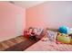 Cozy bedroom features wood floor, pink wall and ample space at 348 Sigmund Loop, Davenport, FL 33837