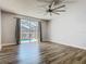 Bedroom featuring hardwood floors, ceiling fan, and sliding glass doors leading to the screened lanai and pool at 348 Sigmund Loop, Davenport, FL 33837
