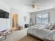 Bright bedroom featuring a large window, TV, ensuite bathroom, and comfortable furnishings at 348 Sigmund Loop, Davenport, FL 33837