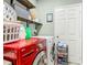 Efficient laundry room with modern washer and dryer, complemented by practical shelving for storage solutions at 348 Sigmund Loop, Davenport, FL 33837