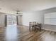 Bright living room with hardwood floors, ceiling fan, dining table, and sliding glass doors leading to the pool at 348 Sigmund Loop, Davenport, FL 33837