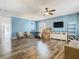 Open-concept living space with hardwood floors, television, and an abundance of natural light at 348 Sigmund Loop, Davenport, FL 33837