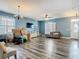 Spacious living room with hardwood flooring, modern blue walls, and television for entertainment at 348 Sigmund Loop, Davenport, FL 33837
