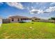 Large grassy backyard enclosed by a fence and featuring a screened in patio at 351 Cloverdale Rd, Winter Haven, FL 33884