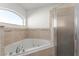 Relaxing tub and shower combination in the neutral-toned bathroom at 351 Cloverdale Rd, Winter Haven, FL 33884
