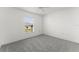 Bright bedroom featuring neutral paint, carpeted floor, and a window overlooking the yard at 351 Cloverdale Rd, Winter Haven, FL 33884