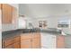 Kitchen sink with wooden cabinets and stainless steel dishwasher open to Gathering room at 351 Cloverdale Rd, Winter Haven, FL 33884