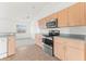 Stainless steel oven and microwave with wooden cabinets and tile flooring at 351 Cloverdale Rd, Winter Haven, FL 33884