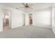 Neutral carpet and ceiling fan in primary bedroom with doors to bath and kitchen at 351 Cloverdale Rd, Winter Haven, FL 33884