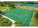 Aerial view of four well-maintained basketball courts surrounded by lush greenery and a walking path at 3868 Whitewood Ct, Oviedo, FL 32766
