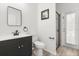 Cozy bathroom featuring black vanity, framed mirror, toilet, and glass door shower at 3868 Whitewood Ct, Oviedo, FL 32766